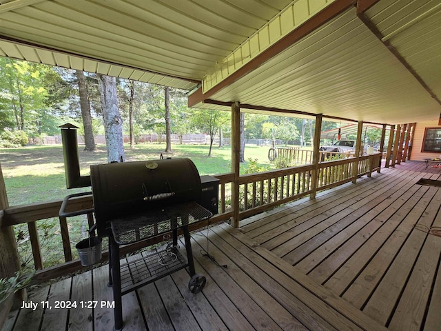 wooden terrace featuring area for grilling and a lawn