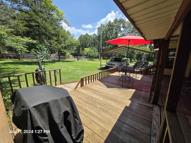 wooden deck featuring area for grilling, a yard, and a carport