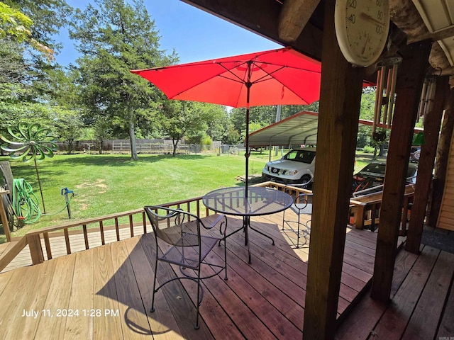 deck featuring a carport and a yard