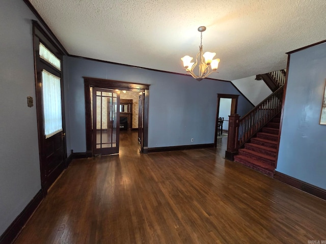 interior space featuring a notable chandelier, a textured ceiling, and dark hardwood / wood-style floors