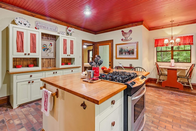 kitchen with a chandelier, white cabinets, pendant lighting, and stainless steel range with gas stovetop