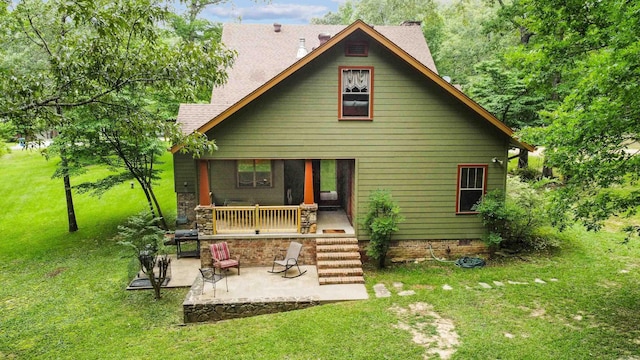 back of property with a yard and a patio