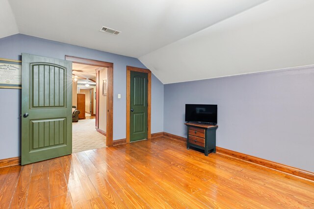 additional living space featuring wood-type flooring and lofted ceiling