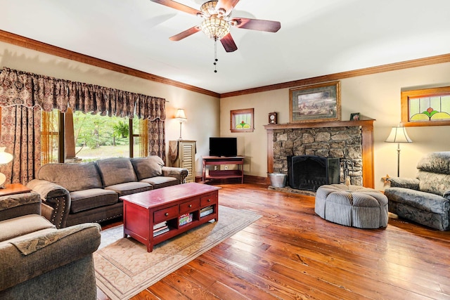 living room with a fireplace, hardwood / wood-style floors, ceiling fan, and crown molding