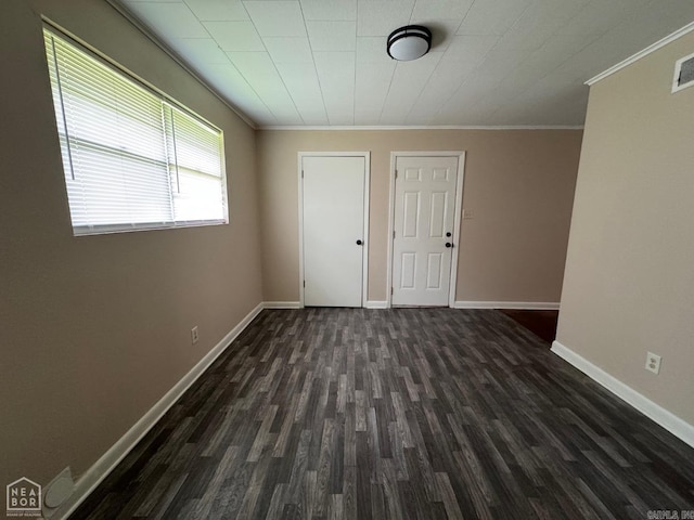 spare room featuring crown molding and dark wood-type flooring