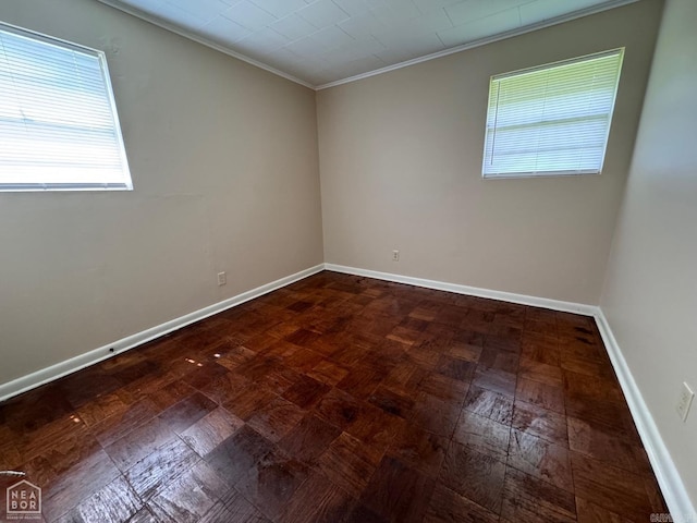 unfurnished room with a healthy amount of sunlight, crown molding, and parquet flooring