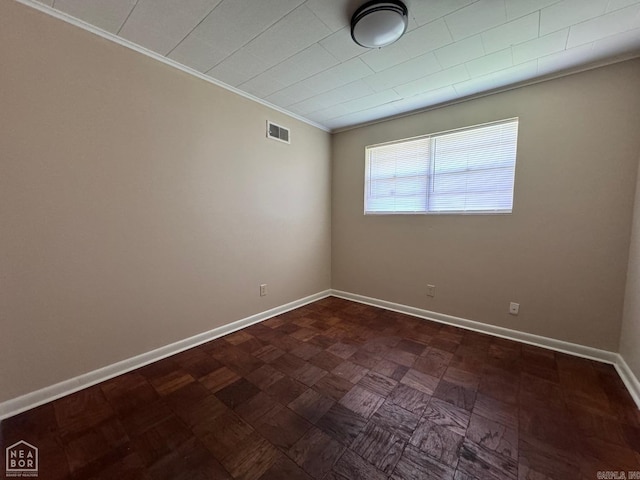 empty room featuring crown molding