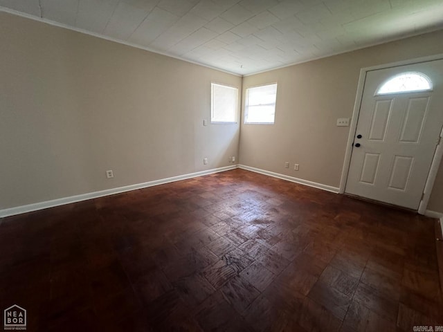 foyer entrance featuring ornamental molding and dark hardwood / wood-style floors