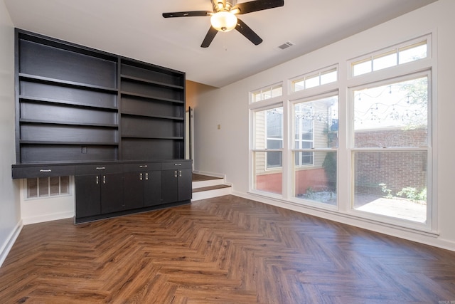 unfurnished living room featuring plenty of natural light, dark parquet floors, and ceiling fan