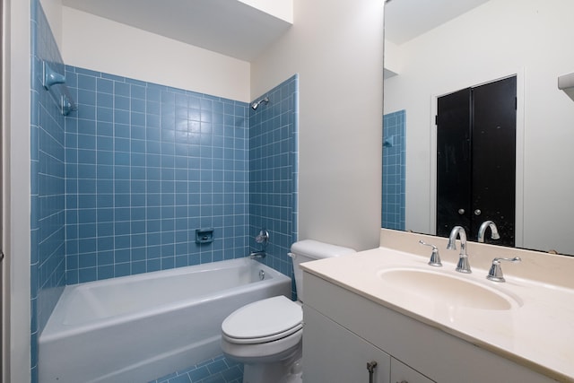 full bathroom featuring tiled shower / bath combo, vanity, and toilet