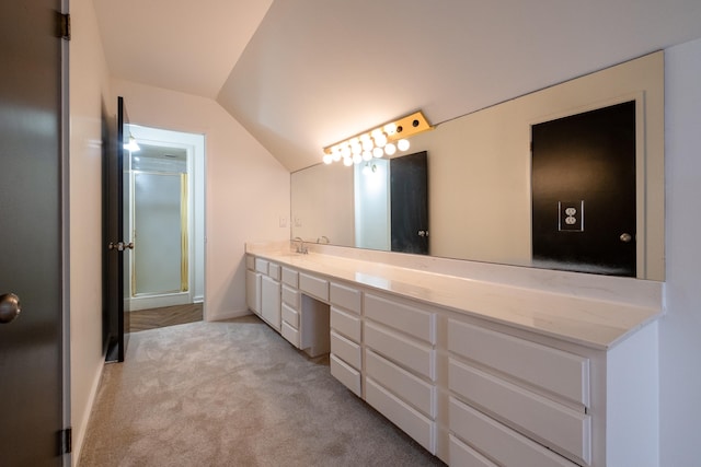 bathroom featuring vanity, vaulted ceiling, and a shower with shower door