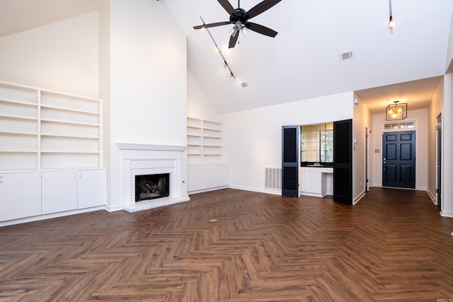 unfurnished living room with ceiling fan, high vaulted ceiling, dark parquet floors, a brick fireplace, and built in shelves