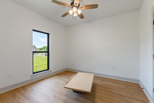 spare room featuring ceiling fan, wood finished floors, and baseboards