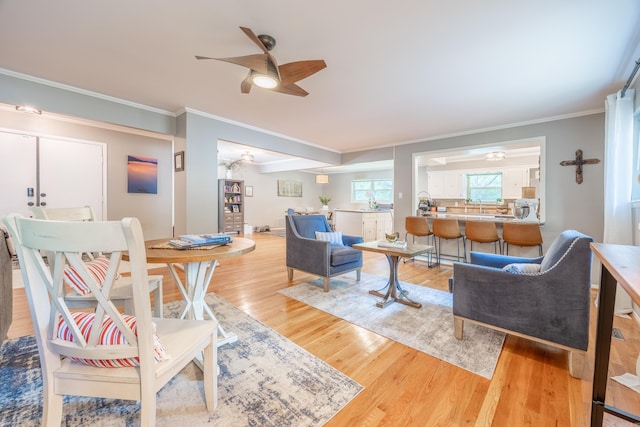 living room with hardwood / wood-style flooring, crown molding, and ceiling fan