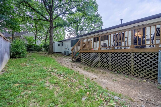 back of property with a yard, a wooden deck, and central AC unit