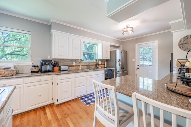 kitchen featuring white cabinetry, stainless steel fridge with ice dispenser, sink, light stone counters, and light hardwood / wood-style flooring