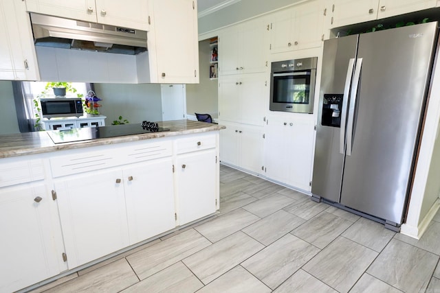 kitchen featuring ornamental molding, appliances with stainless steel finishes, white cabinetry, and light tile patterned floors