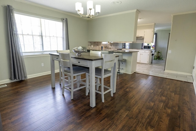 dining area with an inviting chandelier, crown molding, and wood-type flooring