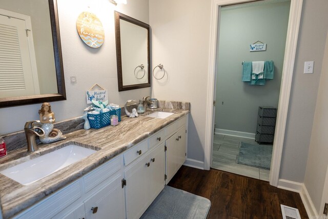 bathroom featuring hardwood / wood-style floors and dual bowl vanity