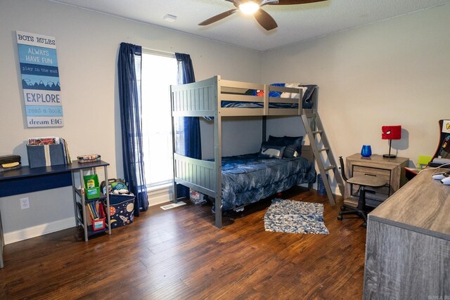 bedroom featuring dark hardwood / wood-style flooring, multiple windows, and ceiling fan