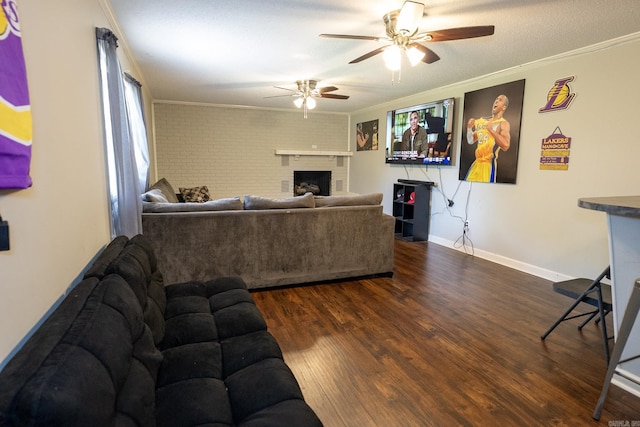 living room featuring dark hardwood / wood-style flooring, a fireplace, ornamental molding, and brick wall