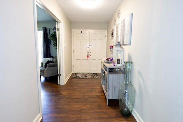 hallway featuring dark wood-type flooring and a textured ceiling