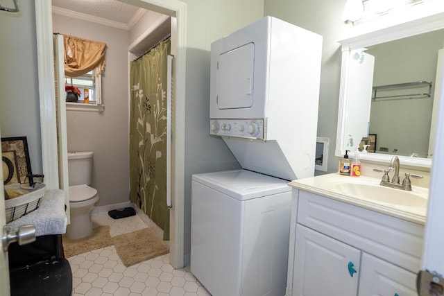 bathroom with crown molding, stacked washer / dryer, toilet, and vanity