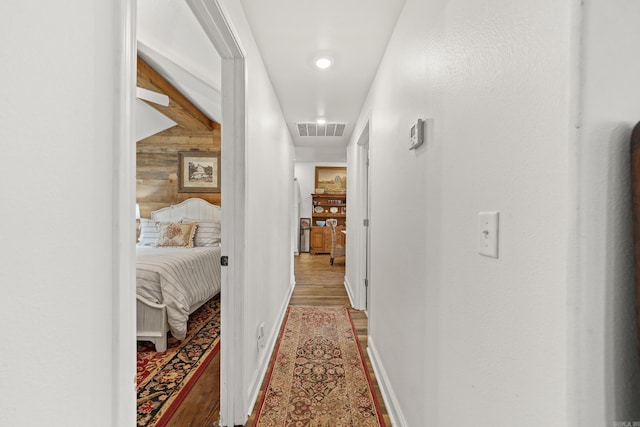 hallway featuring wood walls and hardwood / wood-style floors