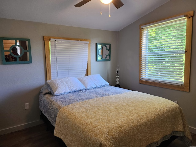 bedroom with dark hardwood / wood-style floors, vaulted ceiling, and ceiling fan