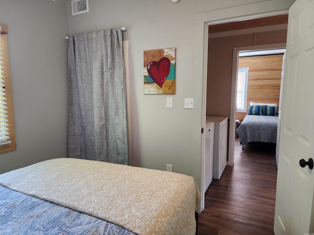 bedroom featuring dark hardwood / wood-style floors and independent washer and dryer