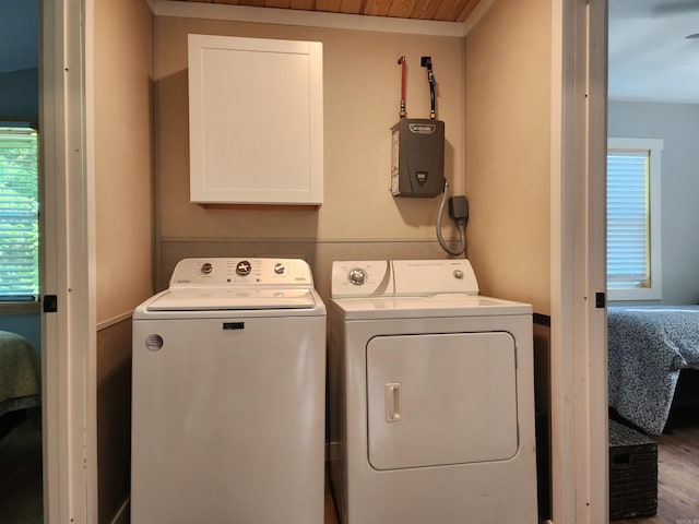 laundry area featuring washer and clothes dryer, cabinets, and hardwood / wood-style floors