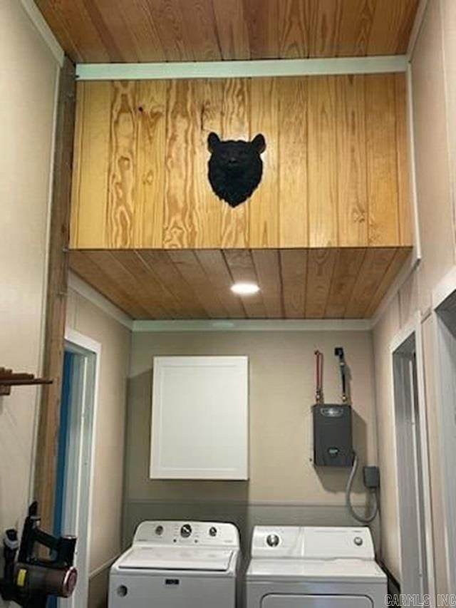 clothes washing area with wood ceiling, washer and dryer, and electric panel