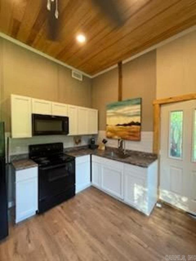 kitchen with light wood-type flooring, wooden ceiling, white cabinets, and electric range oven