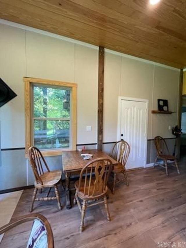 dining room with wooden ceiling, wood-type flooring, and crown molding