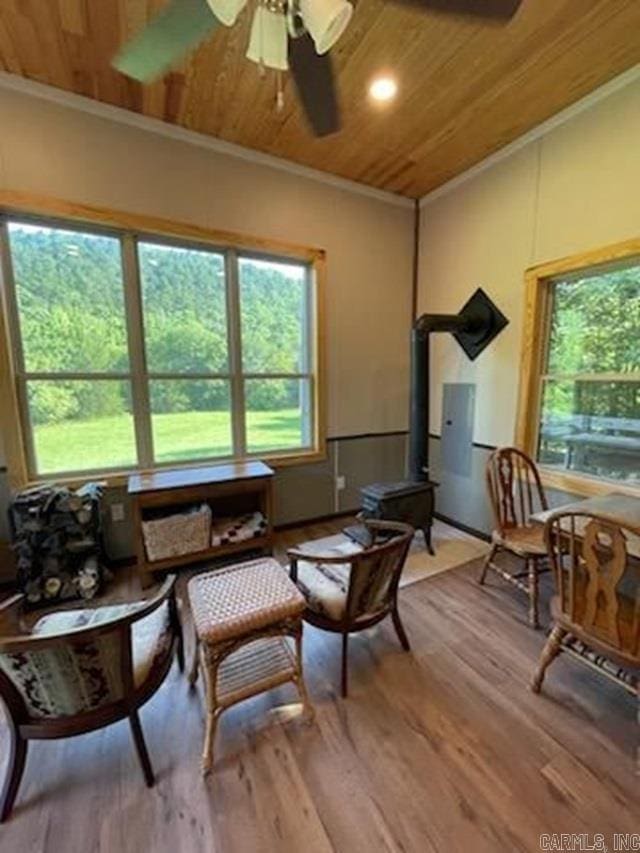 living area with hardwood / wood-style flooring, crown molding, wood ceiling, and ceiling fan