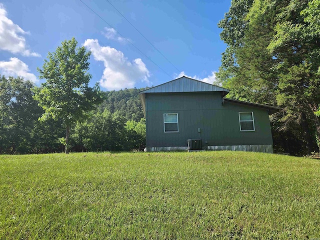 view of side of home featuring a yard and central AC unit