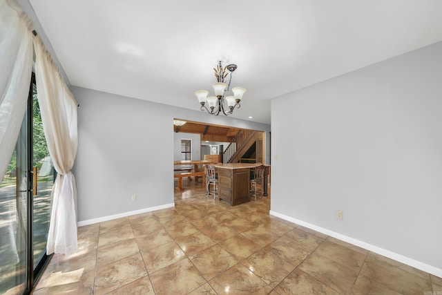 tiled spare room with a chandelier