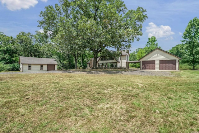 view of yard featuring a garage and an outbuilding