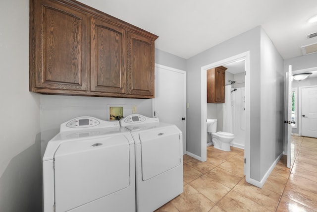 laundry area with washer and dryer, cabinets, and light tile patterned floors