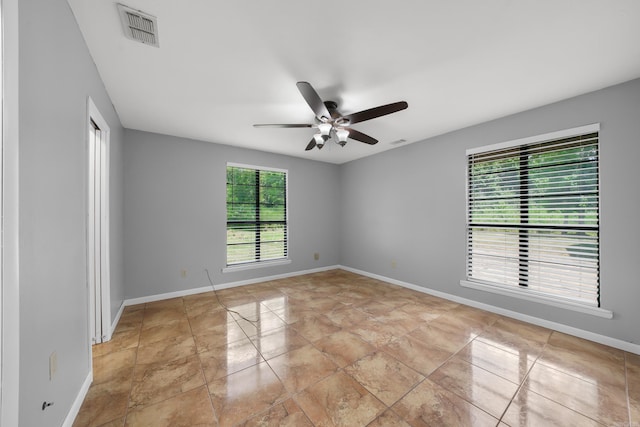 tiled spare room with ceiling fan