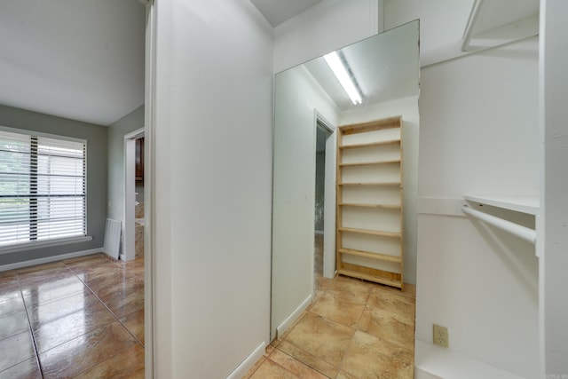 walk in closet with light tile patterned floors