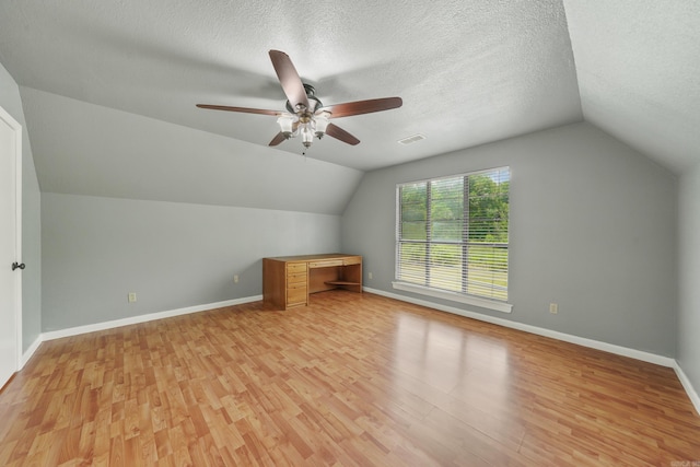 bonus room with a textured ceiling, light hardwood / wood-style flooring, lofted ceiling, and ceiling fan