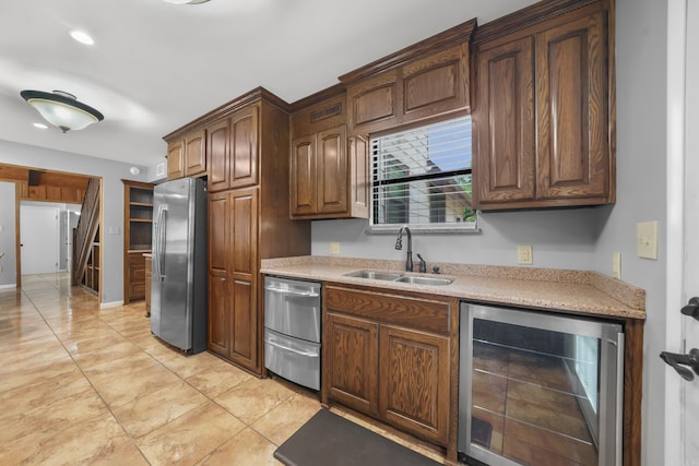 kitchen featuring appliances with stainless steel finishes, sink, light stone counters, light tile patterned flooring, and beverage cooler