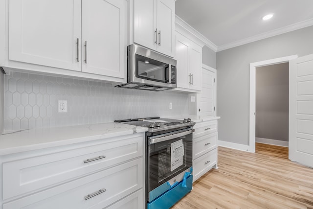 kitchen with ornamental molding, stainless steel appliances, light stone countertops, decorative backsplash, and white cabinets