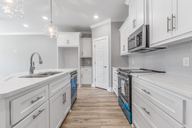 kitchen featuring decorative light fixtures, sink, white cabinets, light stone counters, and stainless steel appliances