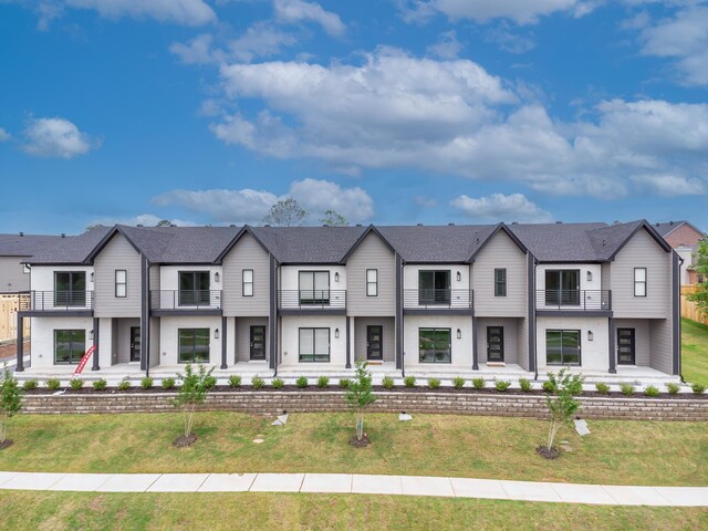 view of front of home featuring a balcony and a front yard