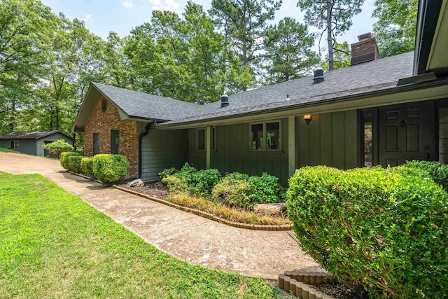 1200 Rock Creek Rd, Hot Springs, AR 71913 - view of home's exterior featuring board and batten siding, a chimney, roof with shingles, a lawn, and brick siding