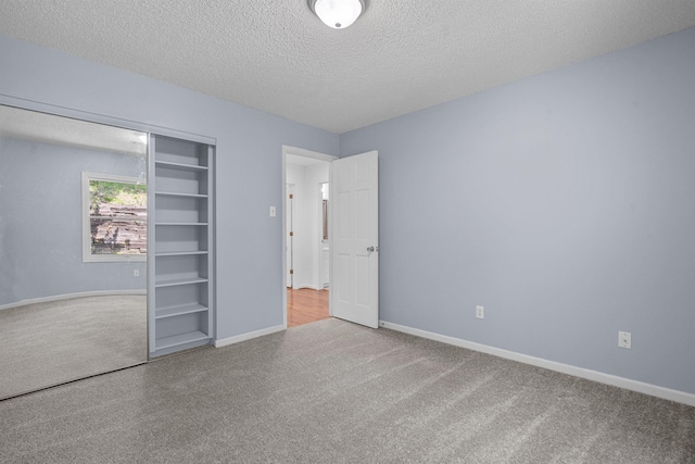 unfurnished bedroom featuring a closet, carpet flooring, and a textured ceiling