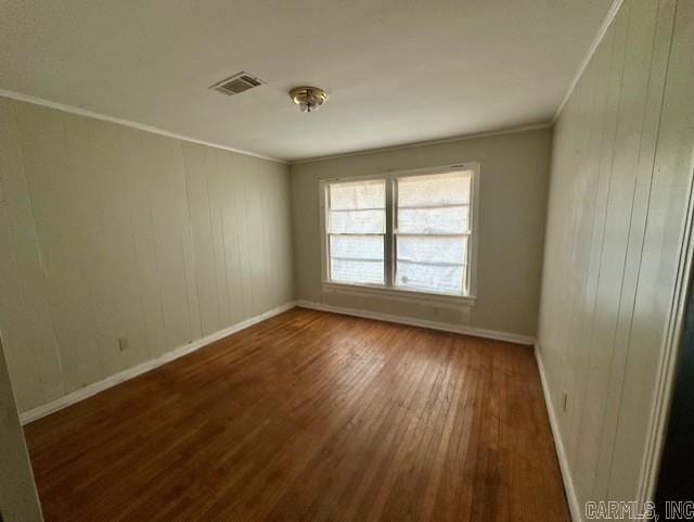 empty room featuring dark hardwood / wood-style flooring and crown molding