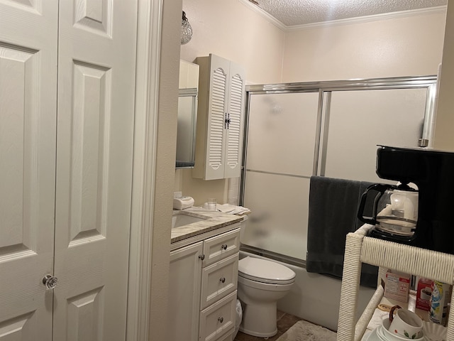 full bathroom featuring crown molding, combined bath / shower with glass door, vanity, a textured ceiling, and toilet